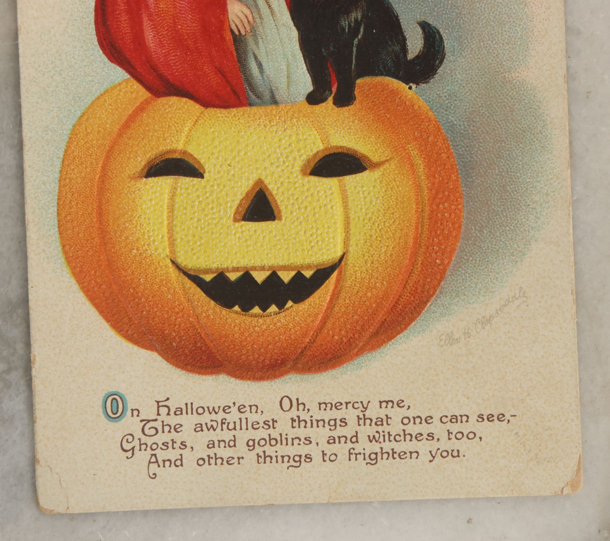 Lot 033 - Antique Embossed Halloween Postcard With Little Girl Witch, Black Cat, Smiling Pumpkin Jack-O-Lantern J.O.L., Illustrated By Ellen Clapsaddle, Series No. 1667, International Art Publishing Co., Printer In Germany, Unused, Note Corner Loss
