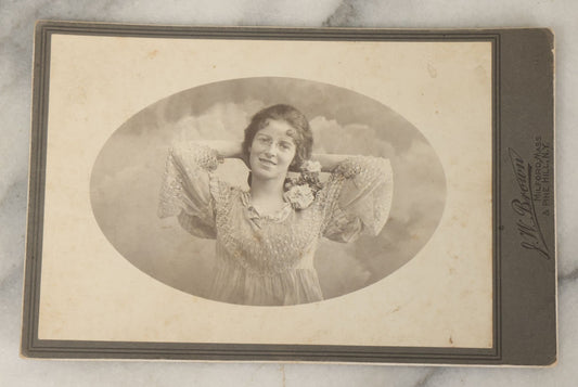 Lot 054 - Antique Cabinet Card Photograph Of A Young Woman In Glasses Posing Playfully With Hands Behind Head, J.W. Brown Photographer, Milford, Massachusetts