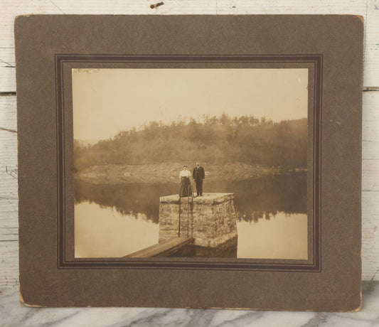 Lot 057 - Antique Boarded Photograph Of A Man And Woman Posing On A Dam