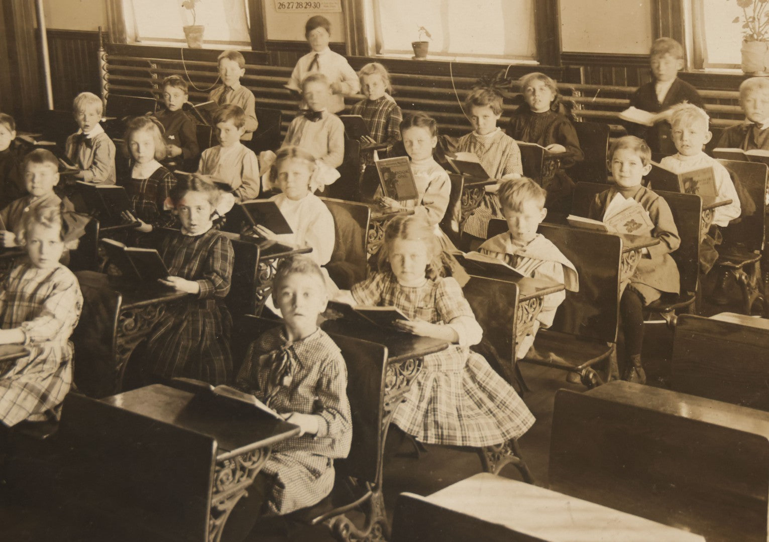 Lot 060 - Antique Boarded Photograph Of The Interior Of A 2Nd Grade Classroom With School Children, Teacher Holding Books,