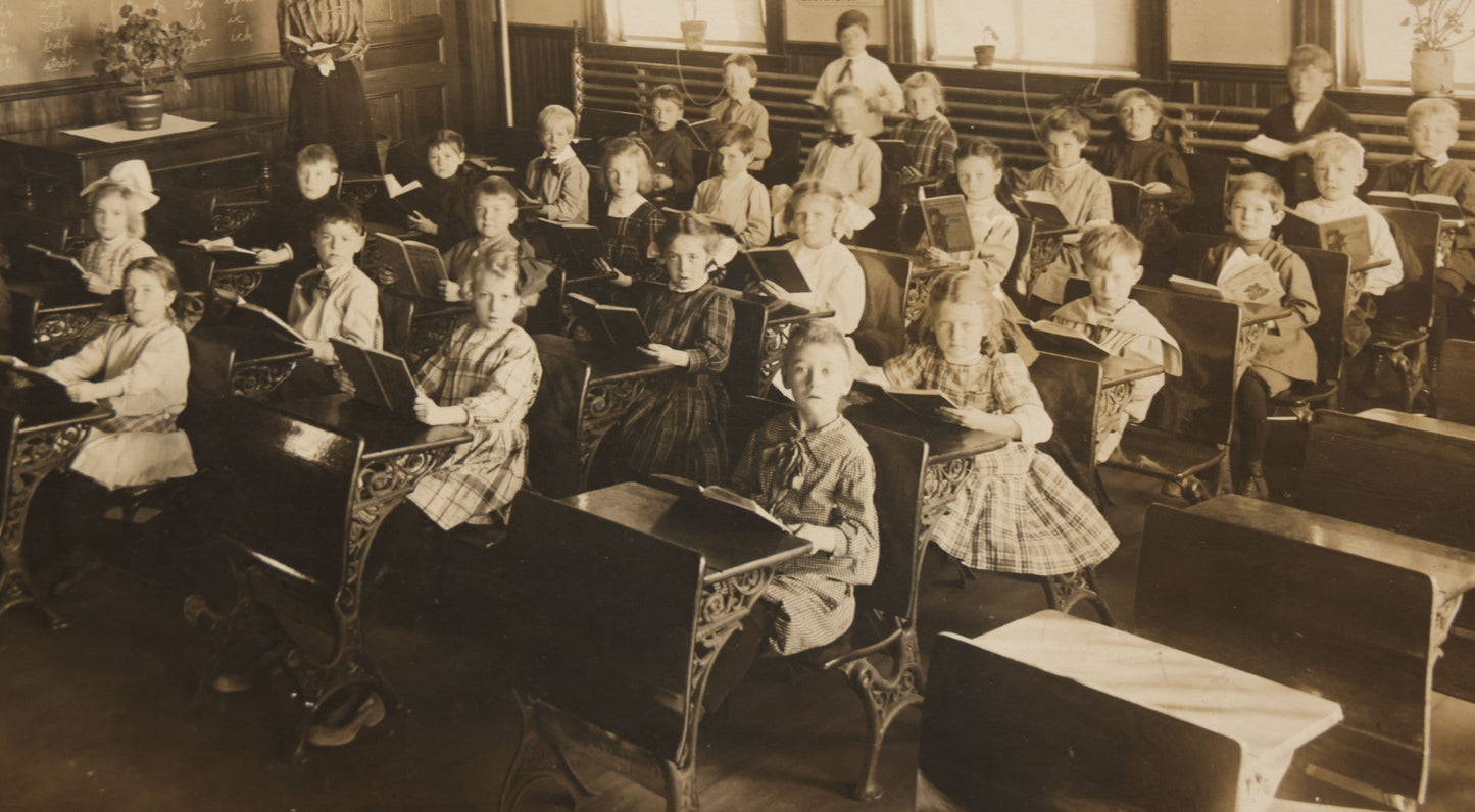 Lot 060 - Antique Boarded Photograph Of The Interior Of A 2Nd Grade Classroom With School Children, Teacher Holding Books,