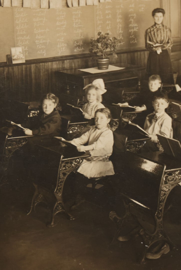 Lot 060 - Antique Boarded Photograph Of The Interior Of A 2Nd Grade Classroom With School Children, Teacher Holding Books,