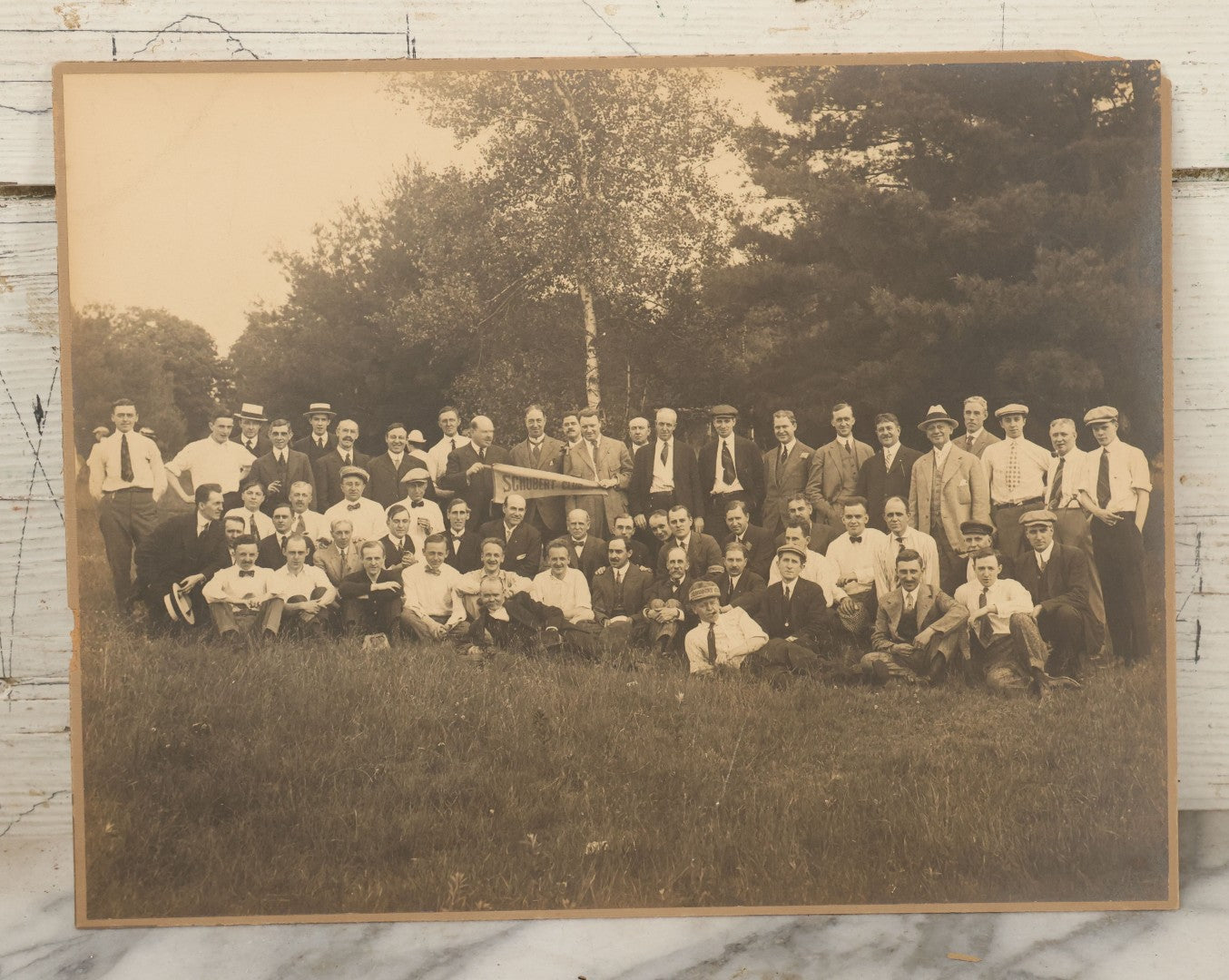 Lot 065 - Antique Boarded Photograph Of The Men Of The Schubert Club, Holding A Pennant, Man With Schubert Hat, Likely The Music Organization Of Saint Paul, Minnesota