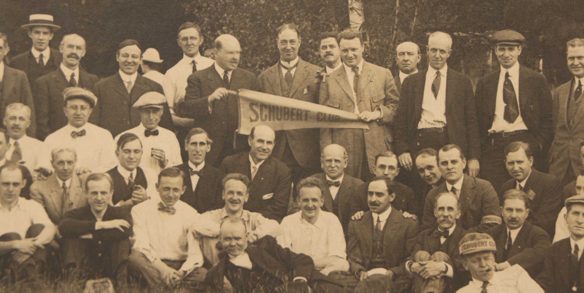Lot 065 - Antique Boarded Photograph Of The Men Of The Schubert Club, Holding A Pennant, Man With Schubert Hat, Likely The Music Organization Of Saint Paul, Minnesota