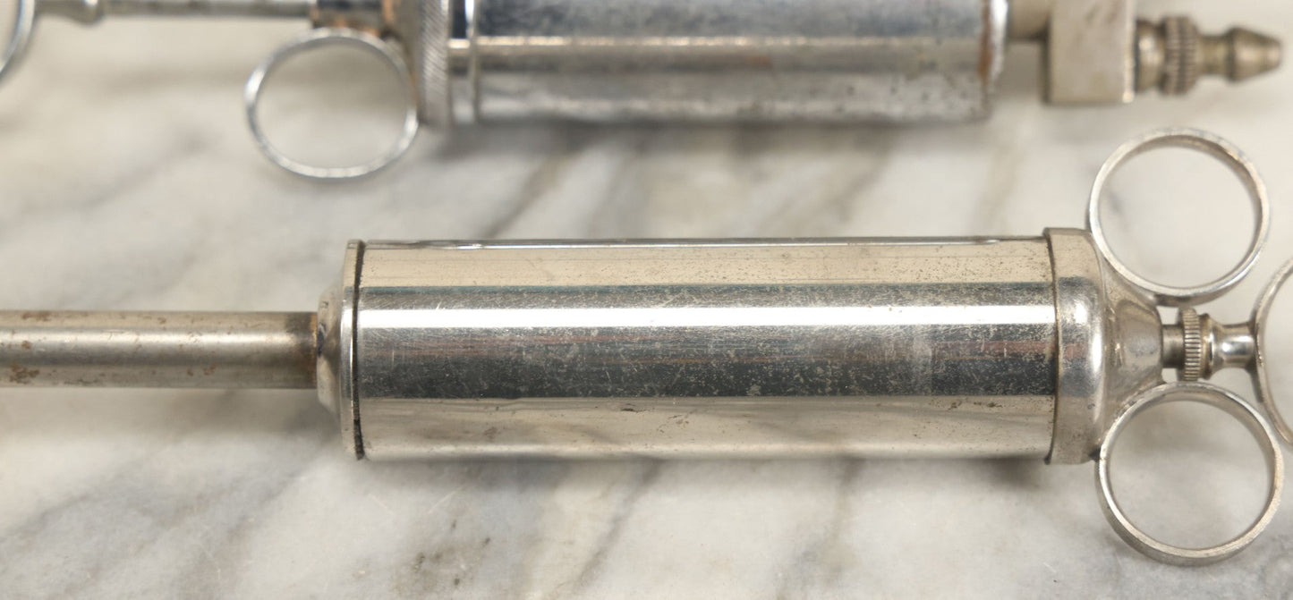 Lot 038 - Pair Of Antique Metal Syringes Including Empire By Becton, Dickinson, & Co., Rutherford, New Jersey