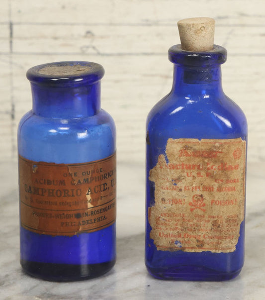 Lot 005 - Pair Of Antique Cobalt Blue Glass Pharmacy Bottles, Including Poison Bottle With Partial Paper Label, And Camphoric Acid Bottle