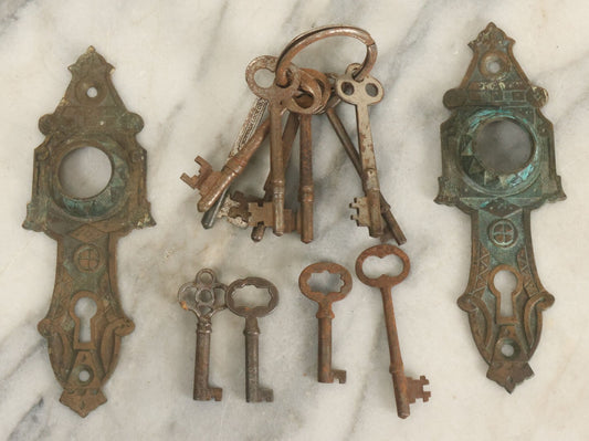 Lot 021 - Grouping Of Ten Antique Skeleton Keys And Two Ornate Antique Doorknob Mount Escutcheons, As Found