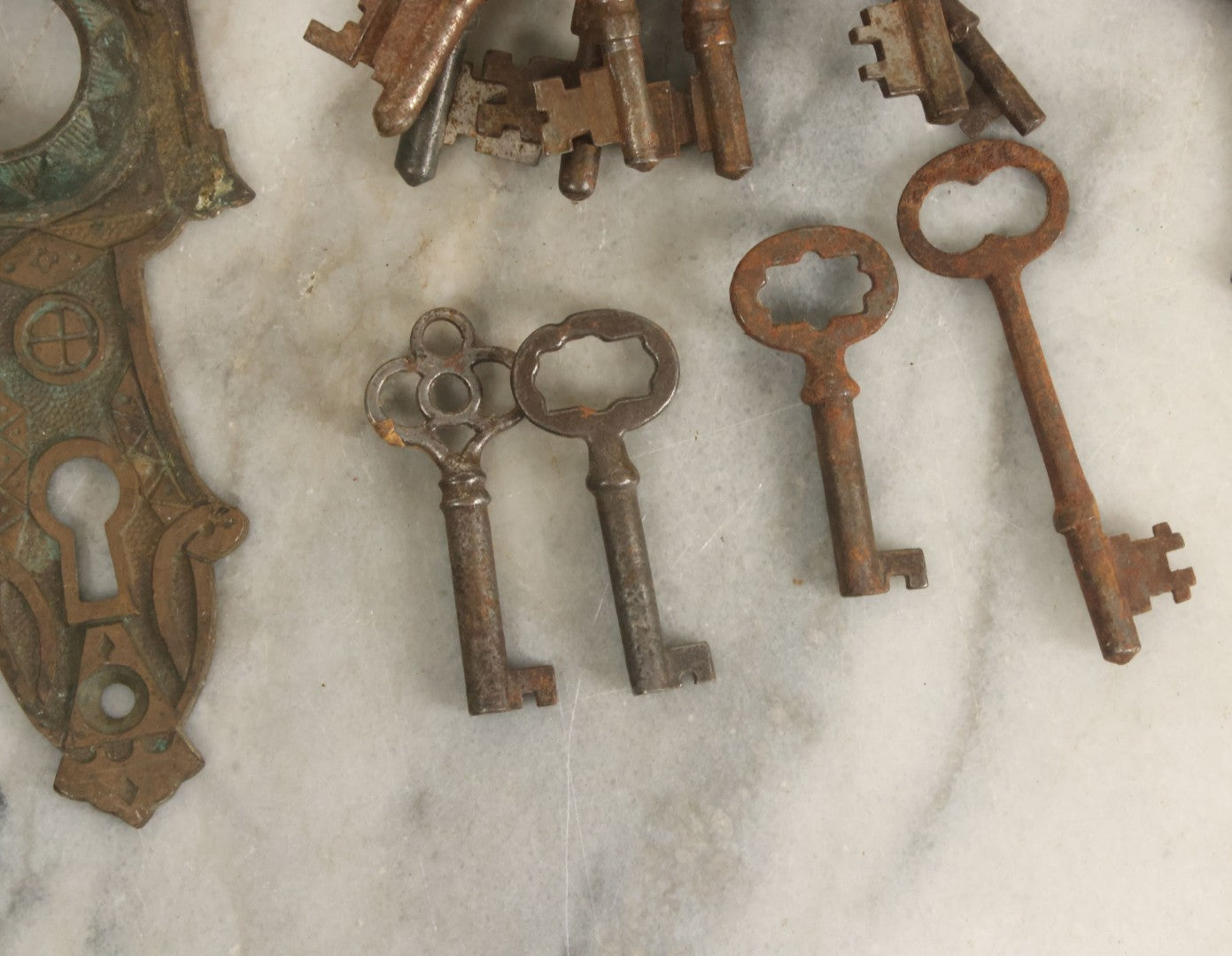 Lot 021 - Grouping Of Ten Antique Skeleton Keys And Two Ornate Antique Doorknob Mount Escutcheons, As Found