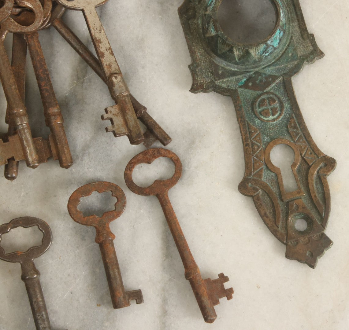 Lot 021 - Grouping Of Ten Antique Skeleton Keys And Two Ornate Antique Doorknob Mount Escutcheons, As Found