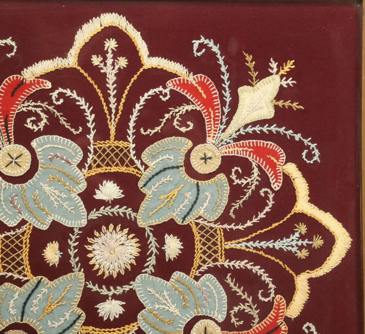 Lot 028 - Vintage Folk Art Needlepoint Embroidery Medallion With Blue, Red, And Yellow Thread On Maroon Field, In Frame
