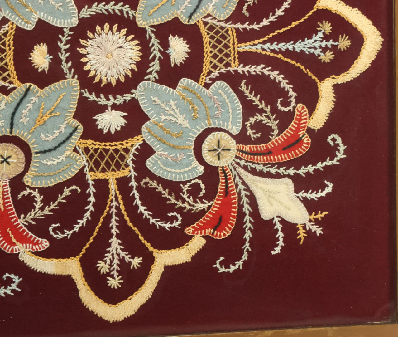 Lot 028 - Vintage Folk Art Needlepoint Embroidery Medallion With Blue, Red, And Yellow Thread On Maroon Field, In Frame