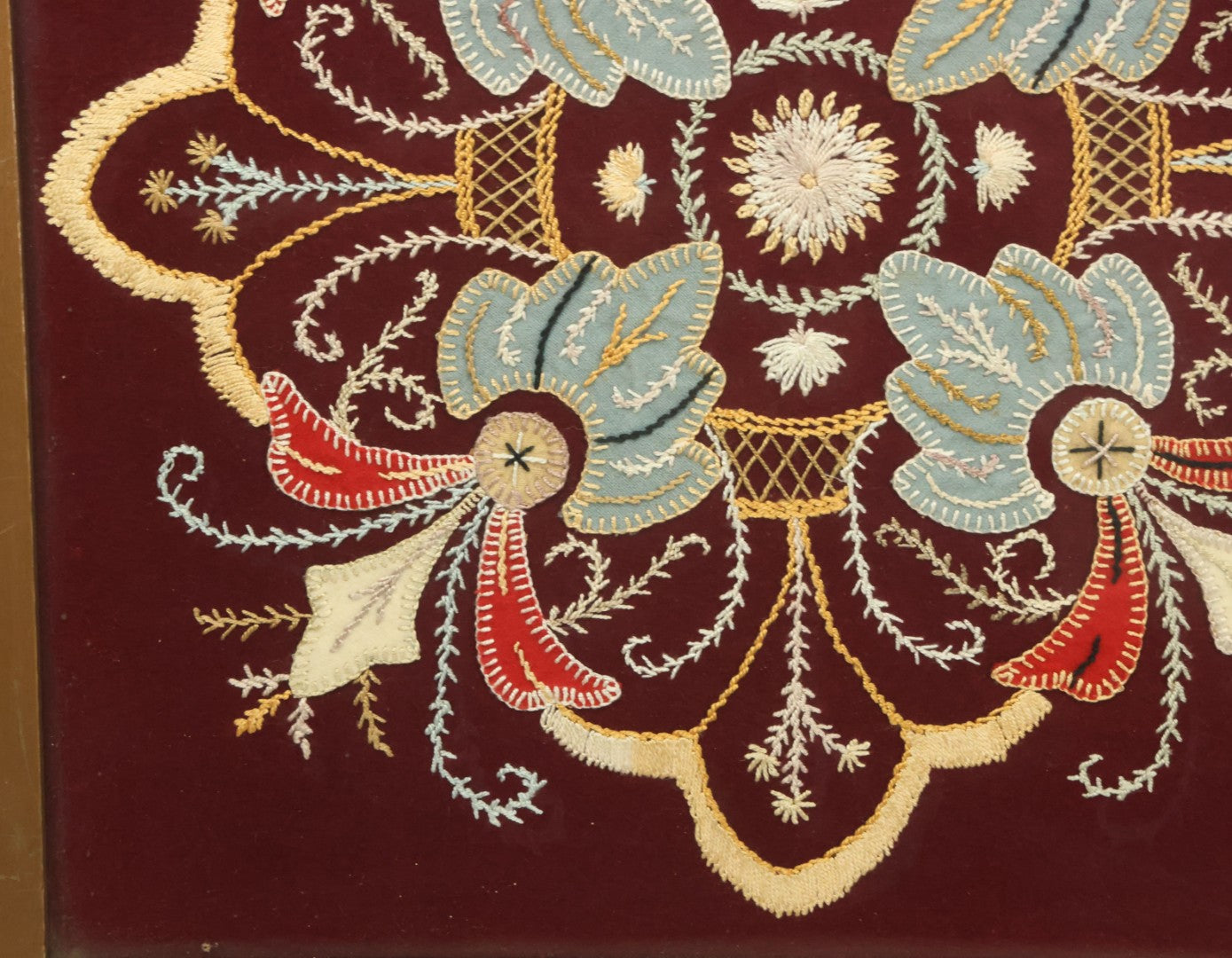 Lot 028 - Vintage Folk Art Needlepoint Embroidery Medallion With Blue, Red, And Yellow Thread On Maroon Field, In Frame