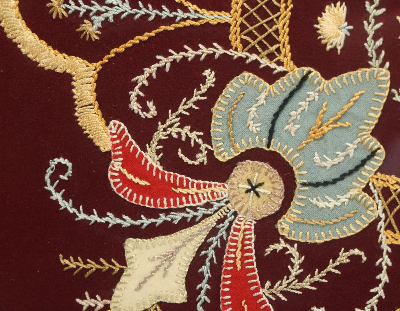 Lot 028 - Vintage Folk Art Needlepoint Embroidery Medallion With Blue, Red, And Yellow Thread On Maroon Field, In Frame