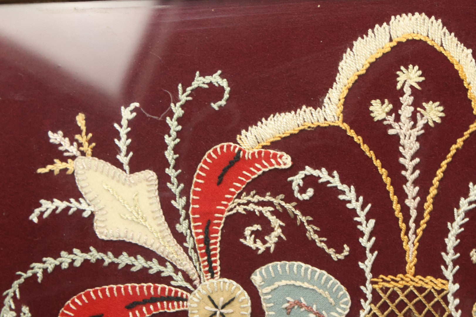 Lot 028 - Vintage Folk Art Needlepoint Embroidery Medallion With Blue, Red, And Yellow Thread On Maroon Field, In Frame
