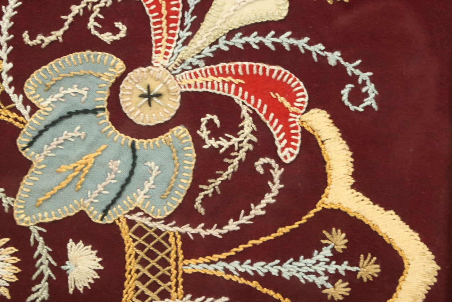 Lot 028 - Vintage Folk Art Needlepoint Embroidery Medallion With Blue, Red, And Yellow Thread On Maroon Field, In Frame