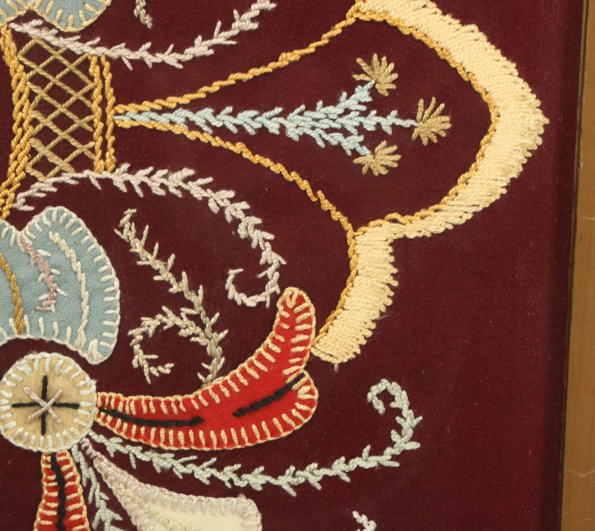 Lot 028 - Vintage Folk Art Needlepoint Embroidery Medallion With Blue, Red, And Yellow Thread On Maroon Field, In Frame