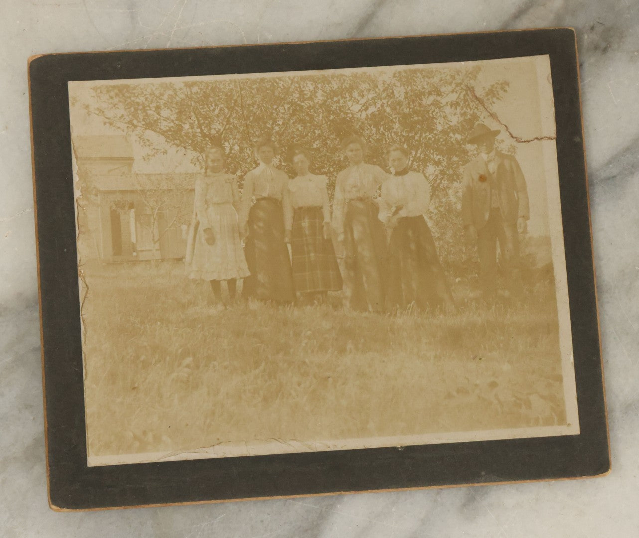 Lot 044 - Grouping Of Five Antique Boarded Photographs Including Worker Posing With Machinery, Exterior Of House, Women Standing By Tree, Horse-Drawn Carriage, And Baby