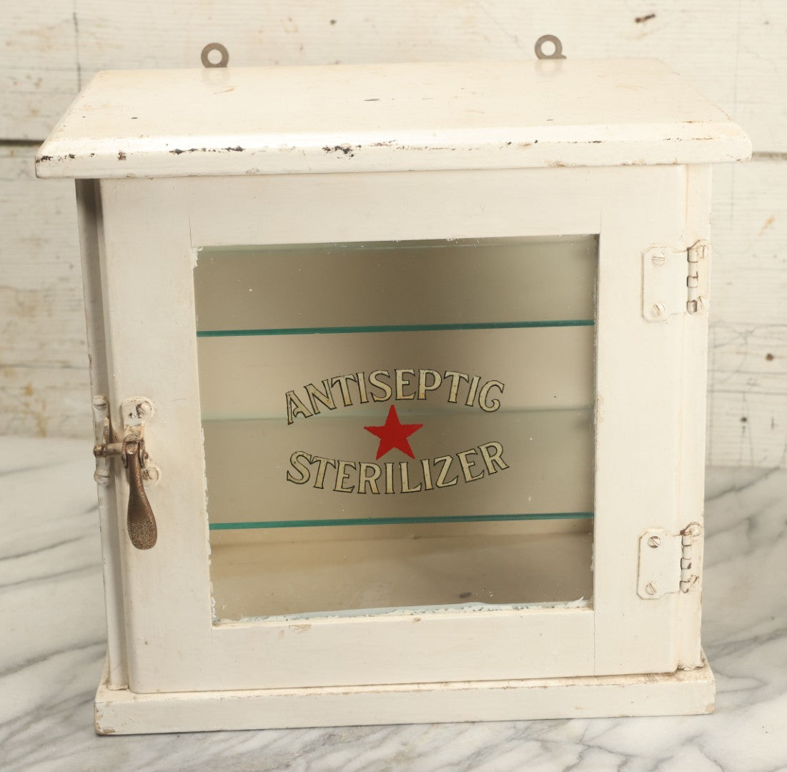 Lot 003 - Antique Wooden Barber Shop Antiseptic Sterilizer Cabinet With Glass Sides, Two Glass Shelves, And White Paint, Some Chipping To Shelves, Overall Dimensions Of Cabinet 13"L x 8-1/2"W x 12"H