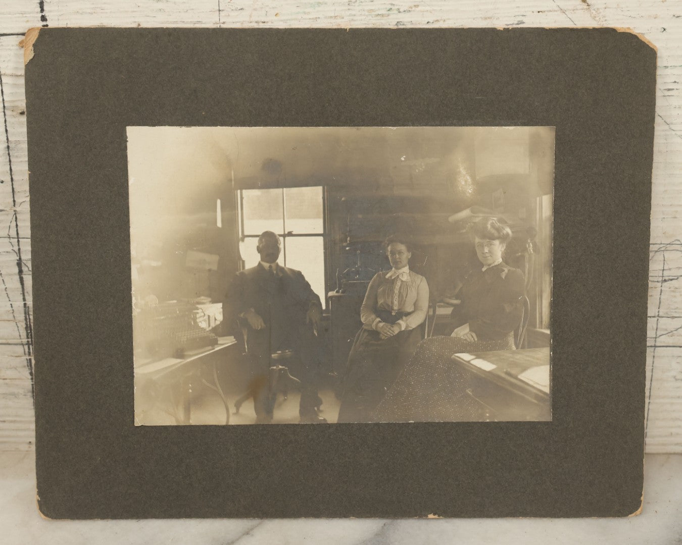 Lot 102 - Pair Of Antique Boarded Occupational Photographs Including Man And Two Women In Office With Book Press, Typewriter, And Faded Photo Of People Posing Outside Of General Store