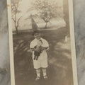 Lot 107 - Single Vintage Snapshot Photograph Of A Young Boy With A Tall Point Hat Holding Stuffed Doll