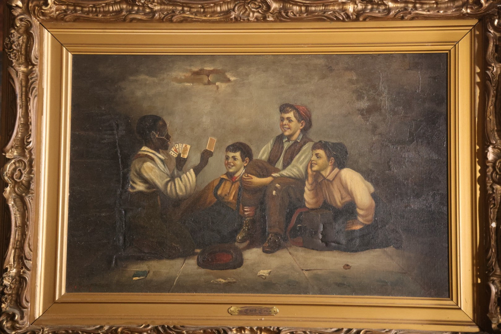 Antique Oil On Canvas Painting Titled "The Card Trick" After John George Brown, Little Boy Showing Off Card Trick To Young Friends, Artist Signed Lower Right, Illegible, In Ornate Frame With Title Plaque, Note Holes, Damage, 37-1/2" x 27-1/2"