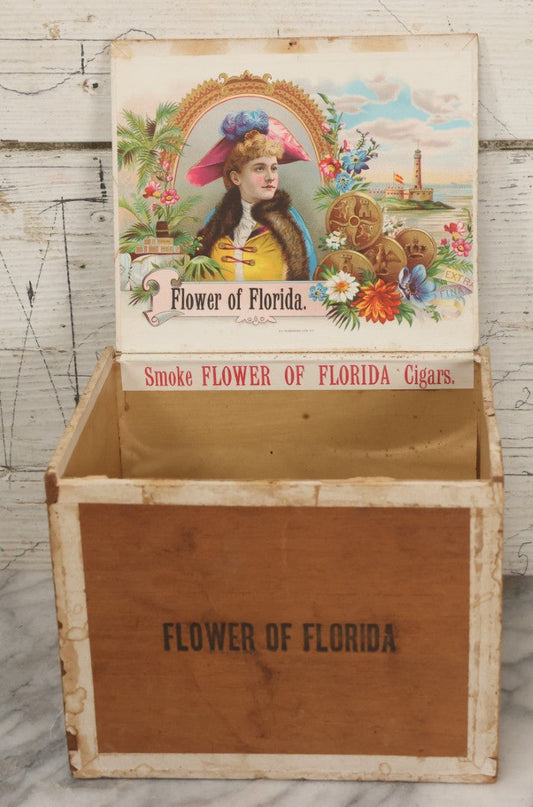 Lot 097 - Antique Wooden Cigar Box With Lithographed Label For Flower Of Florida Cigars, With Woman In Pink Hat & Lighthouse Graphics On External And Internal Labels, Paper Label From Milliken Tomlinson Company, Portland, Maine