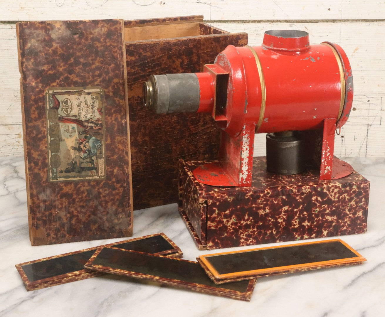 Lot 005 - Antique Magic Lantern Projector In Original Box With Eleven Slides, On Base With Storage Compartment, Original Paper Label Instructions, By Ernst Plank Company, Nuremberg, Germany, Note Missing Metal Chimney