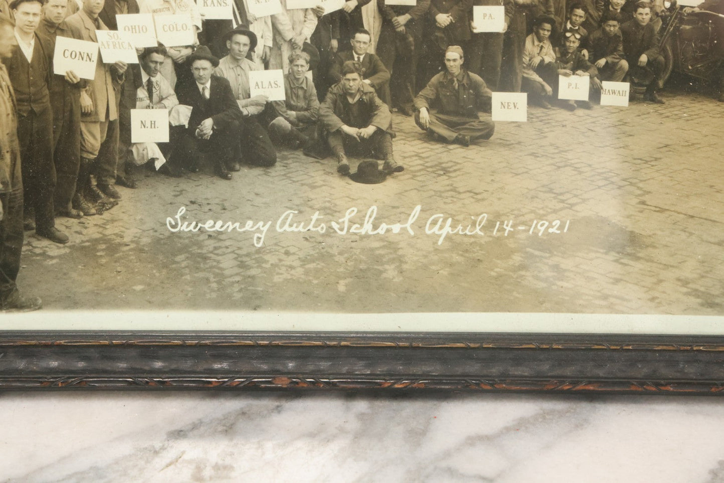 Lot 009 - Antique Framed "Yard-Long" Group Photograph Of The Students Of Sweeney Auto School, April 14th, 1921, Photo Taken By Riederer, Kansas City, Missouri, Note Texas Man On Motorcycle, 21" x 9-1/4"