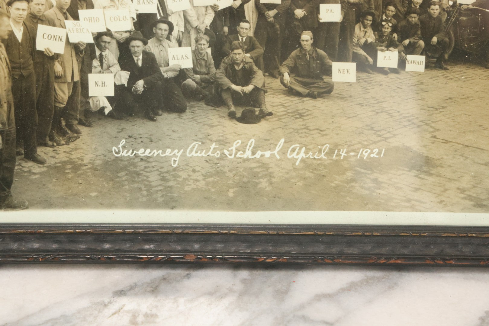 Lot 009 - Antique Framed "Yard-Long" Group Photograph Of The Students Of Sweeney Auto School, April 14th, 1921, Photo Taken By Riederer, Kansas City, Missouri, Note Texas Man On Motorcycle, 21" x 9-1/4"