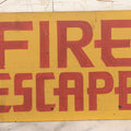 Lot 019 - Vintage Hand Painted "Fire Escape" Tin Sign With Red Lettering On Yellow Field With Wire Hanger, 9-3/4" x 6-1/2"