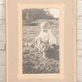 Lot 078 - Antique Snapshot Photograph In Paper Board Frame Of Little Girl Named Gladis With Blond Hair Sitting In Grass With Cat Named Toby, Identified On Verso