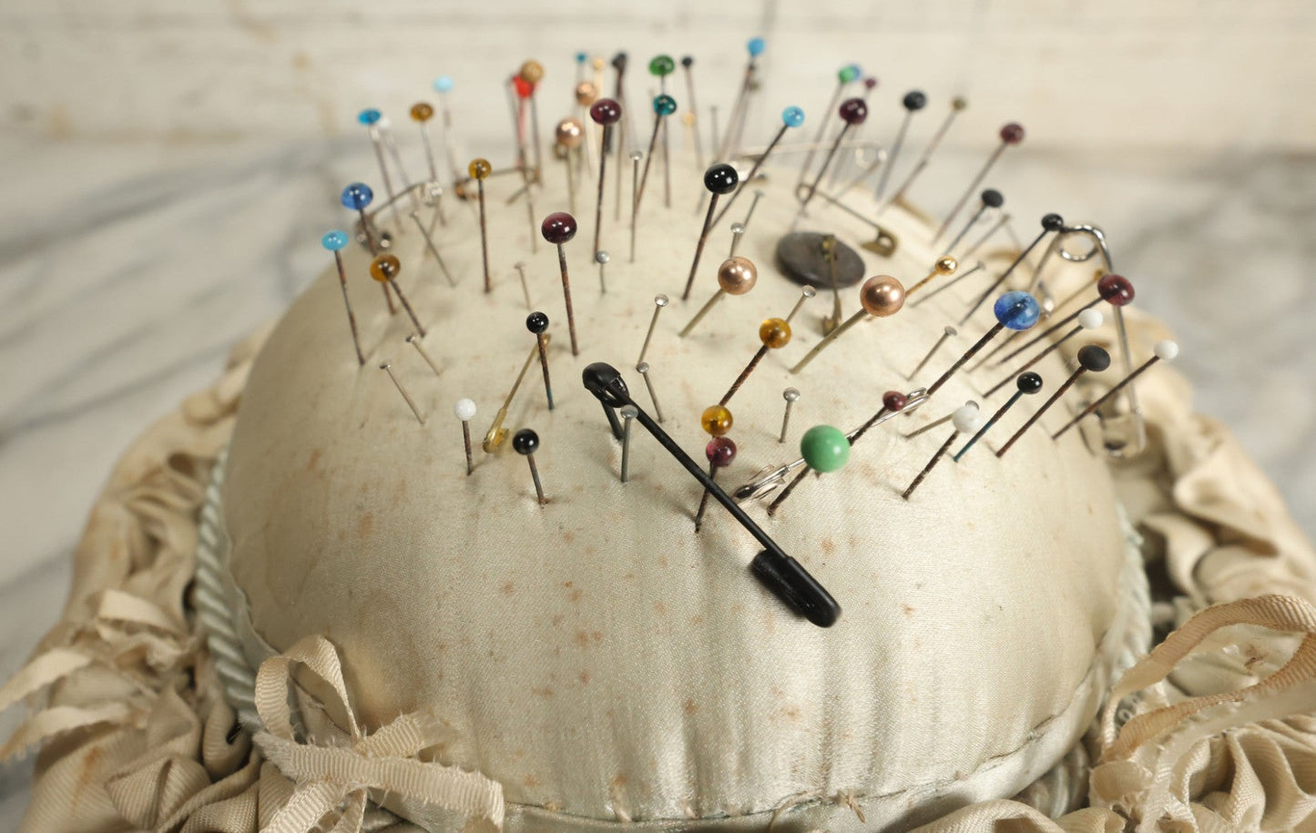 Lot 104 - Vintage Large Size Pincushion With White Silk And Dozens Of Antique With Dozens Of Glass Ball Head Sewing Pins, As Found