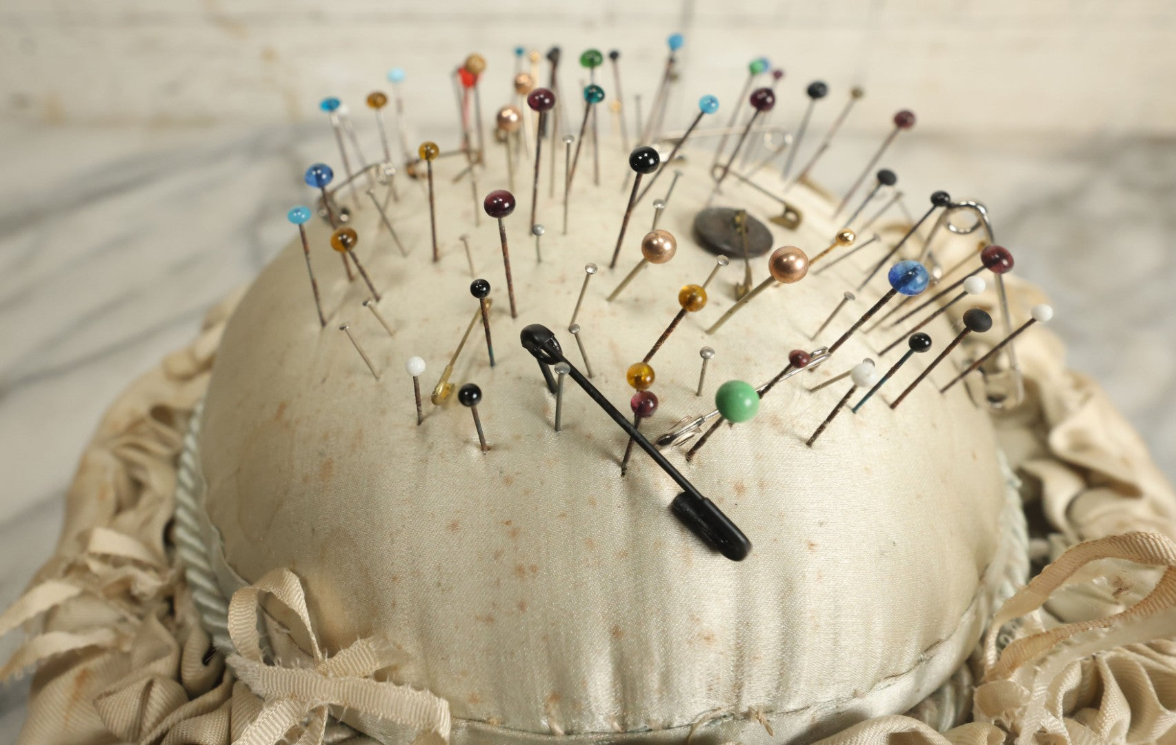 Lot 104 - Vintage Large Size Pincushion With White Silk And Dozens Of Antique With Dozens Of Glass Ball Head Sewing Pins, As Found