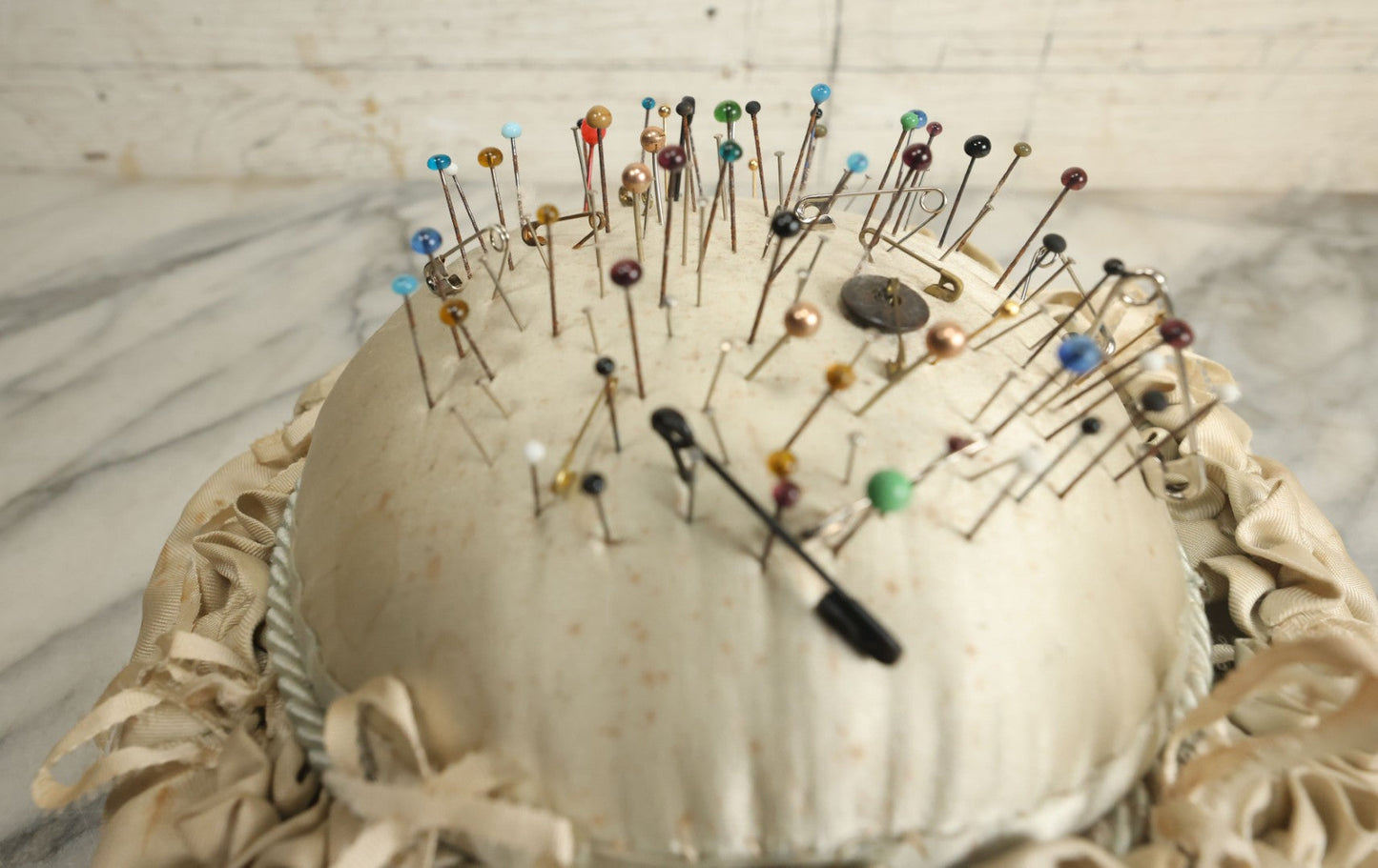 Lot 104 - Vintage Large Size Pincushion With White Silk And Dozens Of Antique With Dozens Of Glass Ball Head Sewing Pins, As Found
