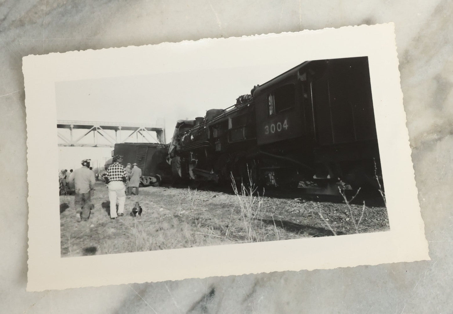 Lot 107 - Grouping Of Five Vintage Snapshot Photographs Showing A Railroad Collision And Derailment With A New Haven Caboose And A Locomotive With Trust Bridge Visible In Background, Circa 1940