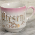 Lot 131 - Antique Porcelain Mug With Pink And Gold "Present" Decoration, Bottom Marked Made In Germany