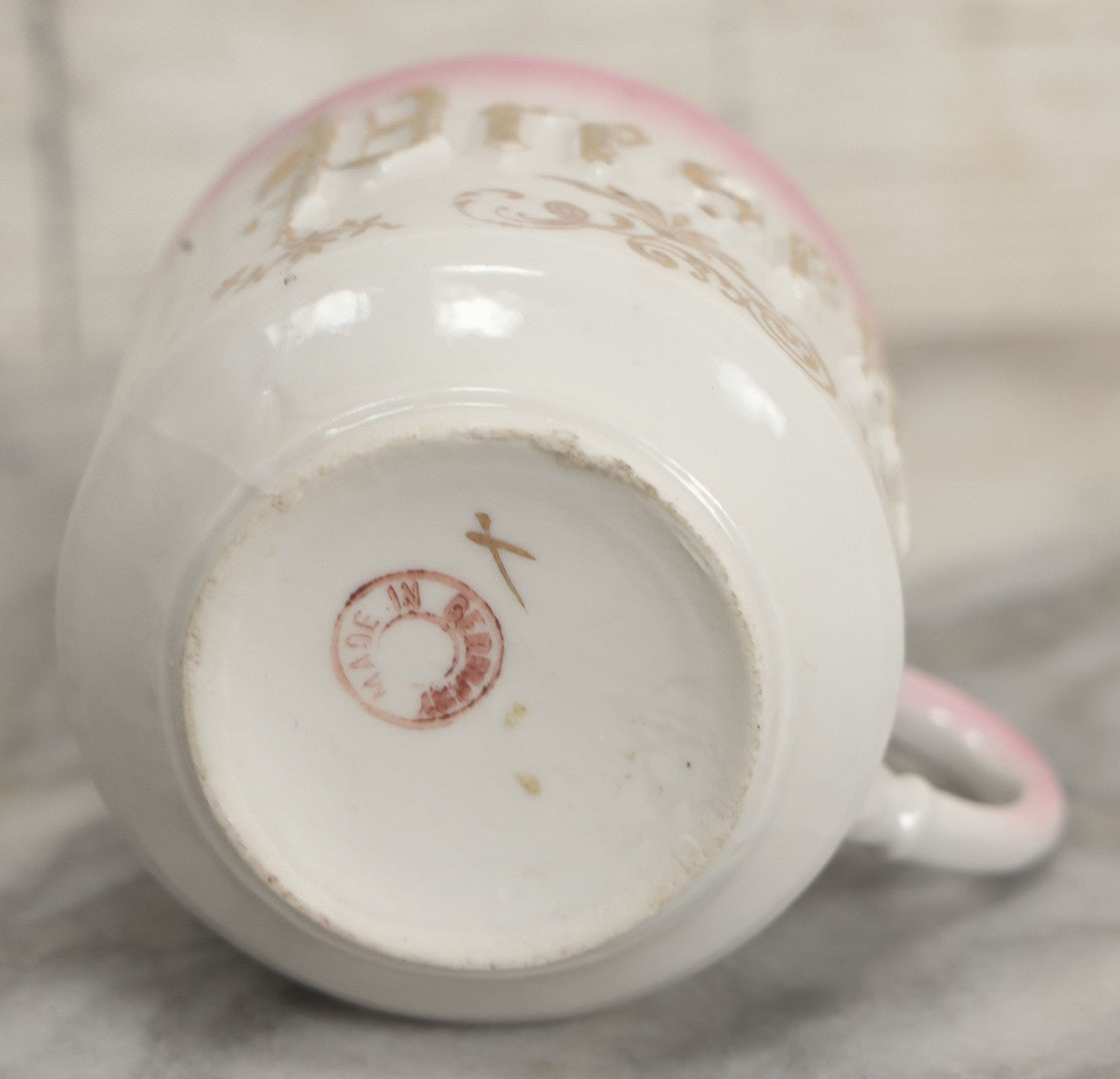 Lot 131 - Antique Porcelain Mug With Pink And Gold "Present" Decoration, Bottom Marked Made In Germany