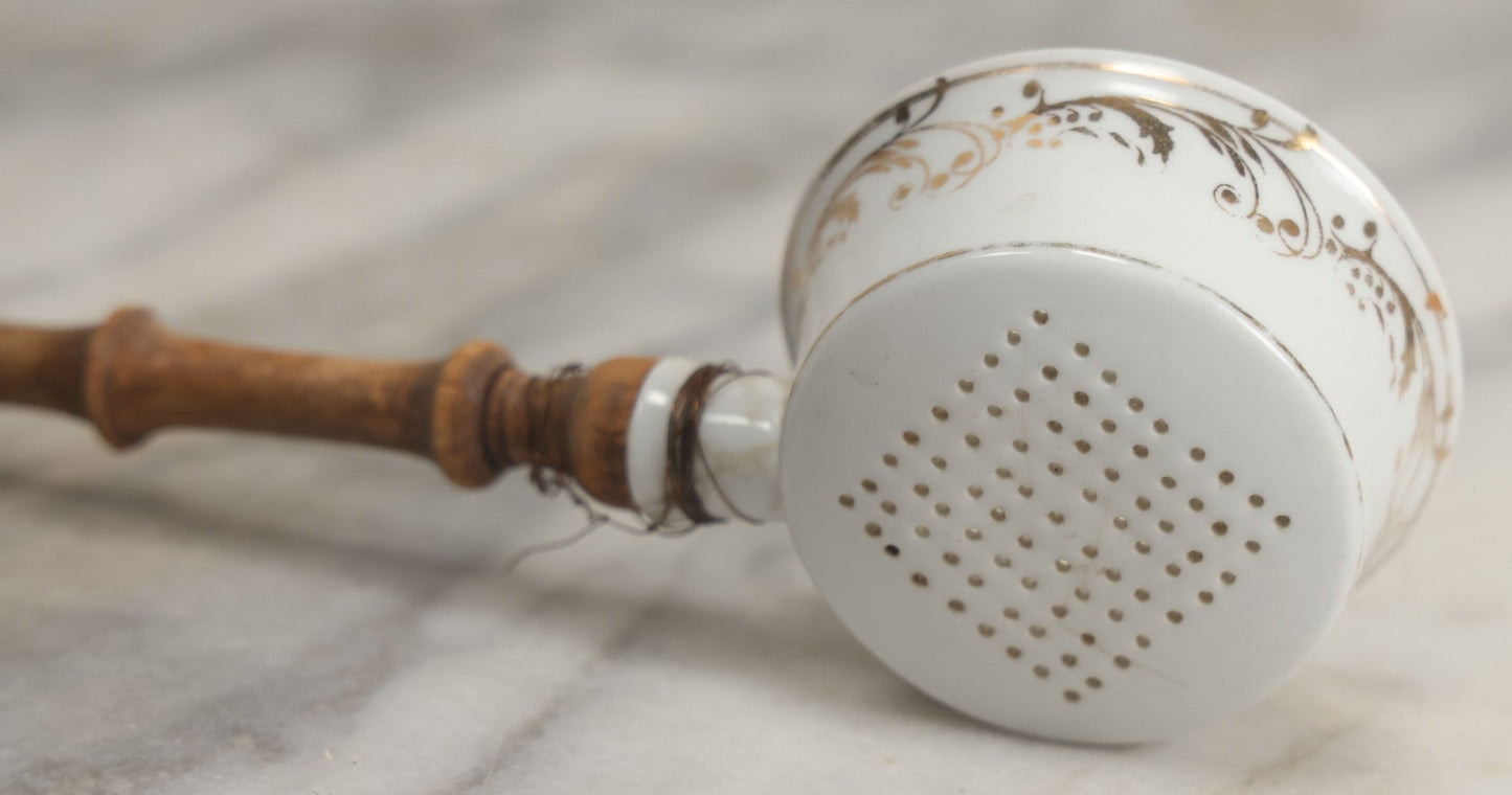 Lot 132 - Vintage Porcelain Tea Strainer With Gold Painted Details And Wire Attached Wooden Handle, Note Repairs