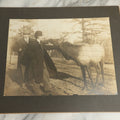 Lot 082 - Antique Boarded Photograph Of Two Men Petting An Elk Through A Chicken Wire Fence