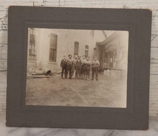 Lot 071 - Antique Boarded Occupational Photograph Of Group Of Seven Dirty Workers Posing In Work Clothes Outside Brick Workplace