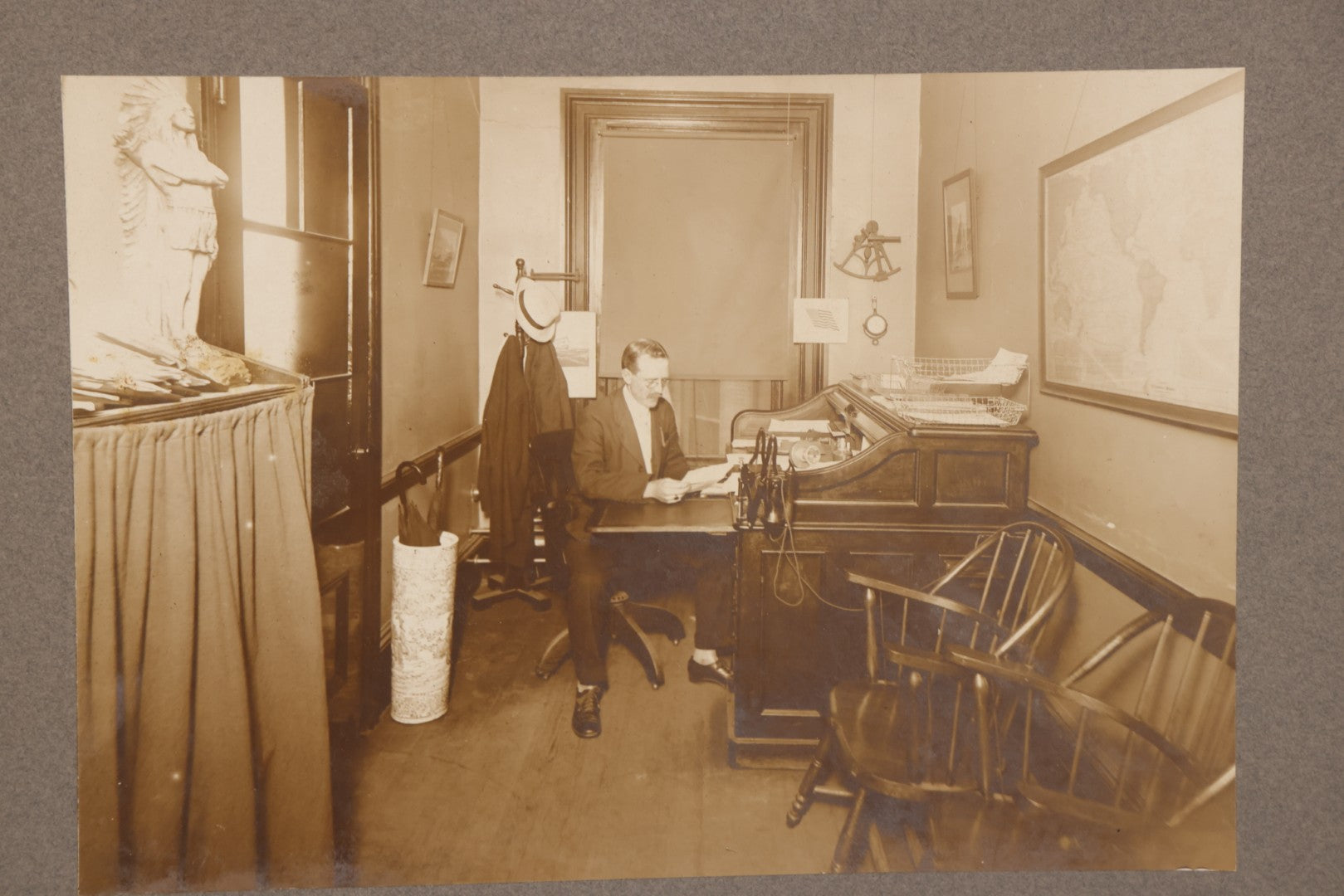 Lot 081 - Antique Boarded Occupational Photograph Of Man In His Office With Map, Sextant, And Telephone Visible In Photo
