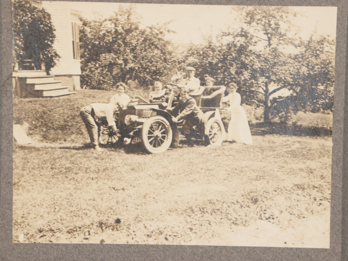 Lot 089 - Antique Boarded Photograph Of Group Of People Posing With And Starting An Early Automobile