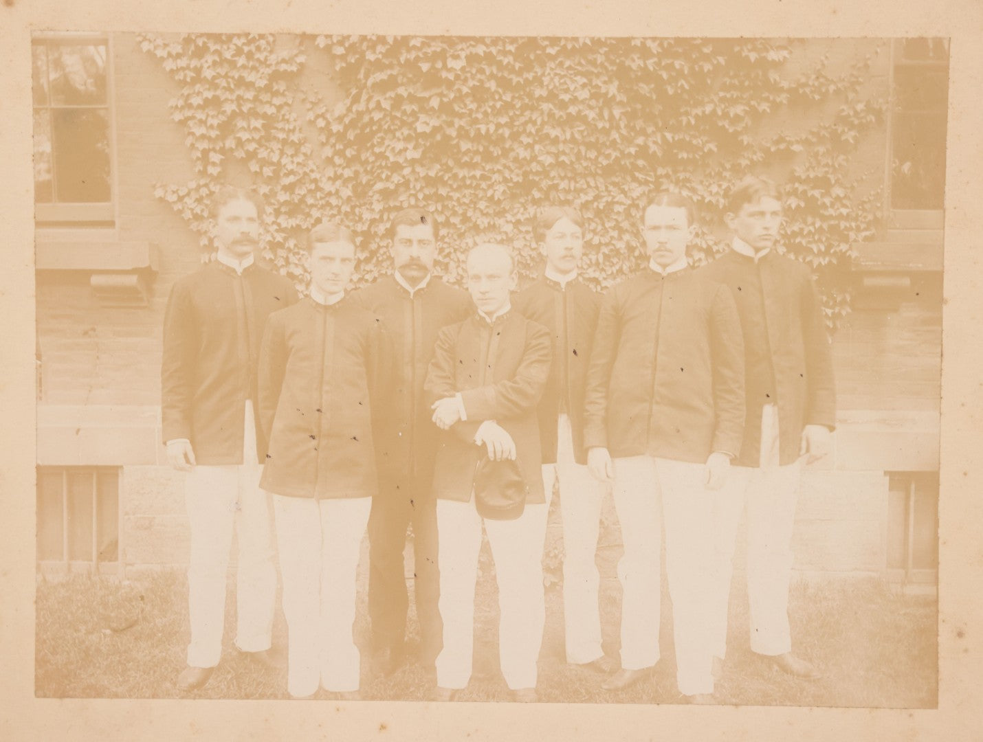 Lot 092 - Antique Boarded Photograph Of Group Of Seven Men In Formal Dress, Likely Military Cadets, Insignia On Collar Says "B.H."