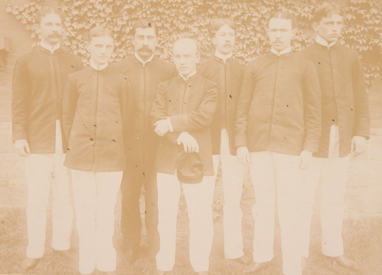 Lot 092 - Antique Boarded Photograph Of Group Of Seven Men In Formal Dress, Likely Military Cadets, Insignia On Collar Says "B.H."