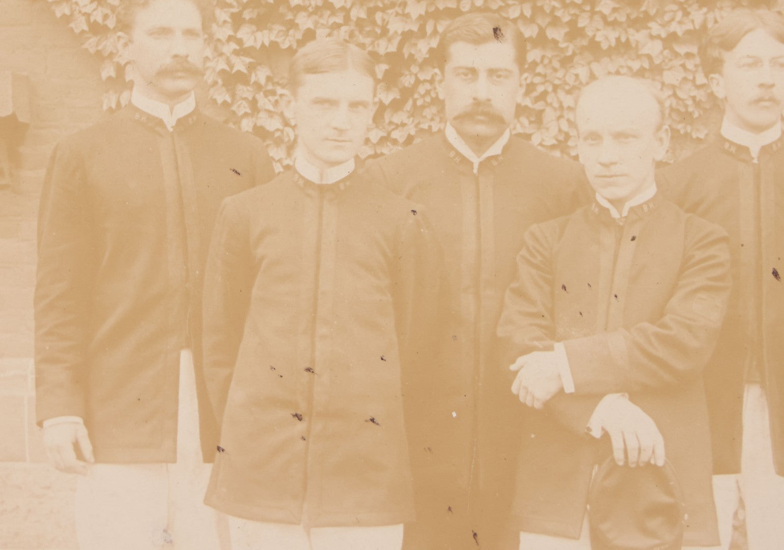 Lot 092 - Antique Boarded Photograph Of Group Of Seven Men In Formal Dress, Likely Military Cadets, Insignia On Collar Says "B.H."