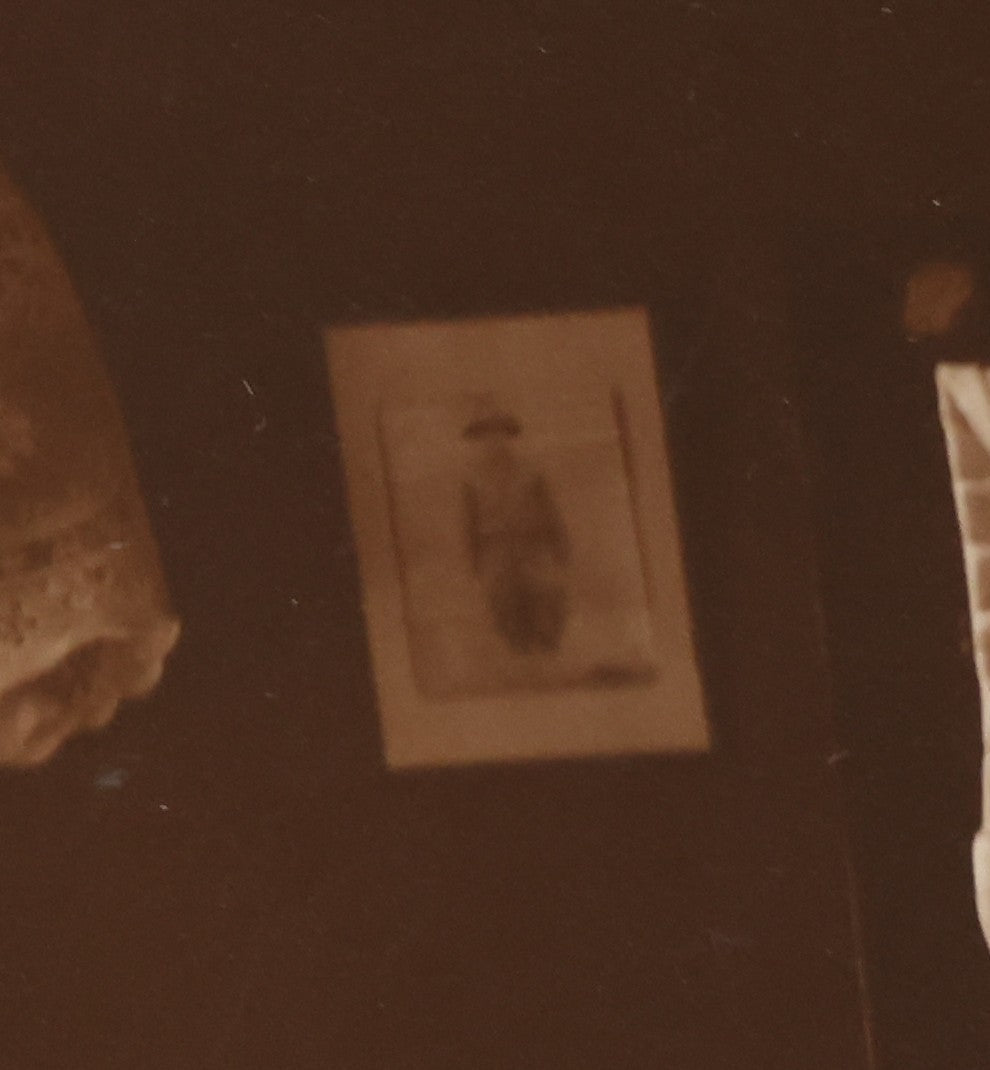 Lot 101 - Vintage Paper Funeral Photograph Of Young Man In Coffin Adorned With Floral Arrangements And "Dear Brother" Ribbon, Crosses, Photos, Candles And Religious Art Visible, Including Photo Of WWI Soldier In Top Left