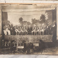 Lot 110 - Antique Boarded Photograph Of Stage Performers In Costume With Painted Backdrop And Drum Set, Music Stands In Foreground