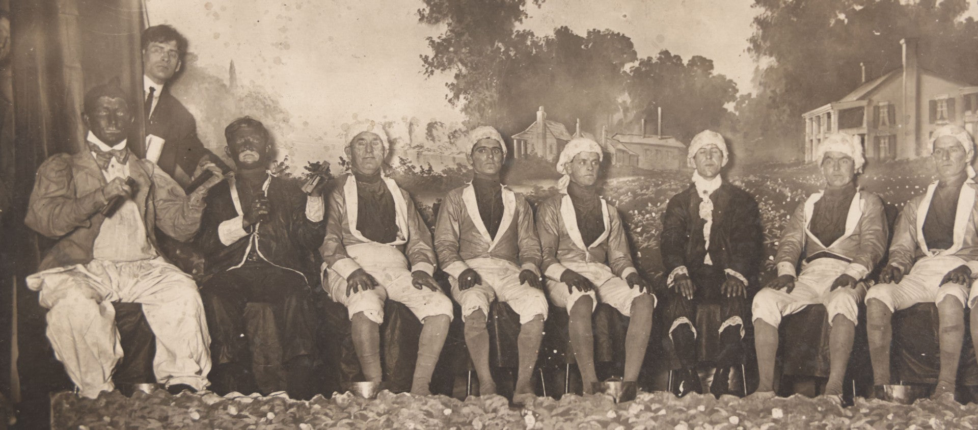 Lot 110 - Antique Boarded Photograph Of Stage Performers In Costume With Painted Backdrop And Drum Set, Music Stands In Foreground