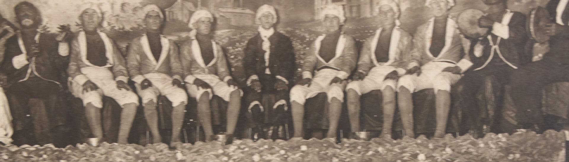 Lot 110 - Antique Boarded Photograph Of Stage Performers In Costume With Painted Backdrop And Drum Set, Music Stands In Foreground