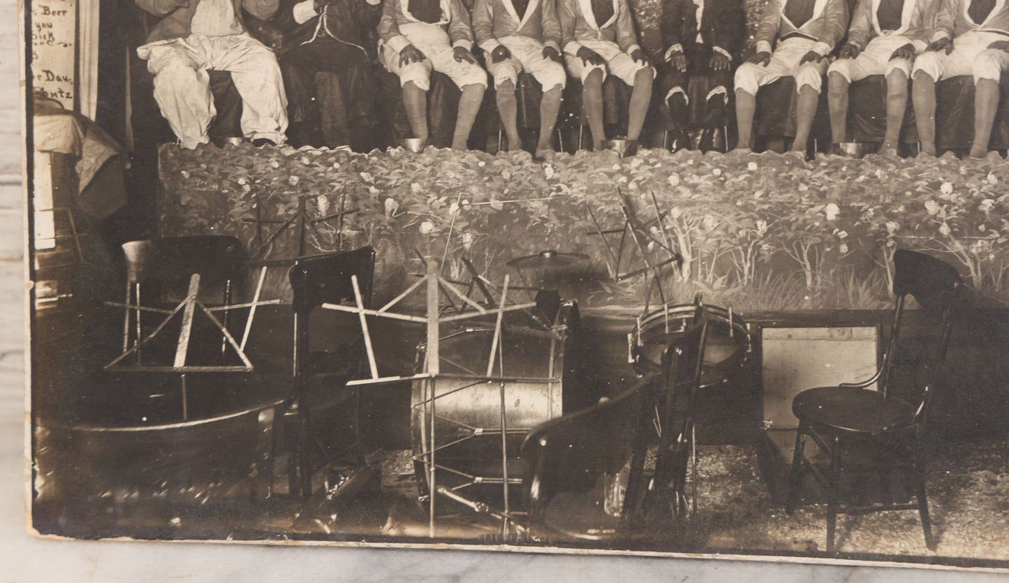 Lot 110 - Antique Boarded Photograph Of Stage Performers In Costume With Painted Backdrop And Drum Set, Music Stands In Foreground